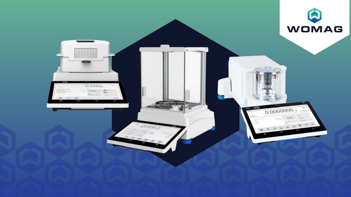 White laboratory-grade analytical balances with digital touchscreen displays and transparent glass enclosures, branded by womag