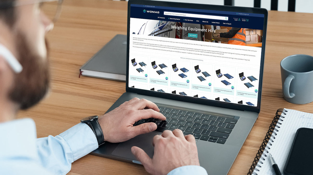 Silver laptop displaying a womag website for weighing equipment hire
