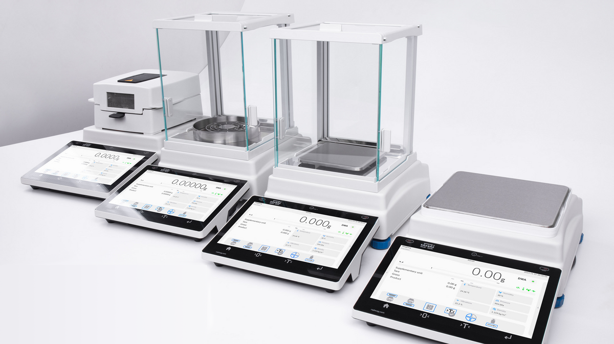 White digital laboratory balances with glass draft shields and touchscreen interfaces