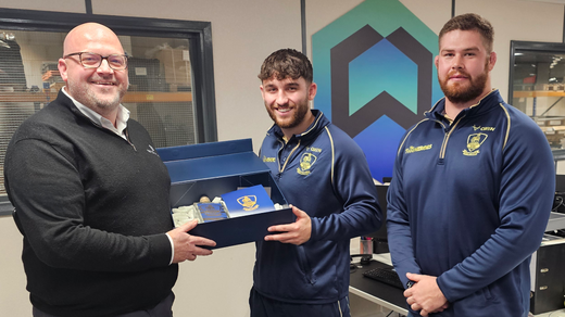 Blue presentation box with a matching lid, containing an award or certificate inside