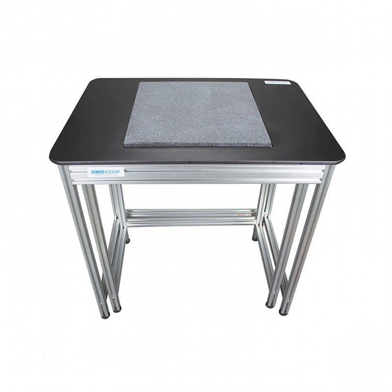 Black desktop with silver metal legs and a gray textured mat on top