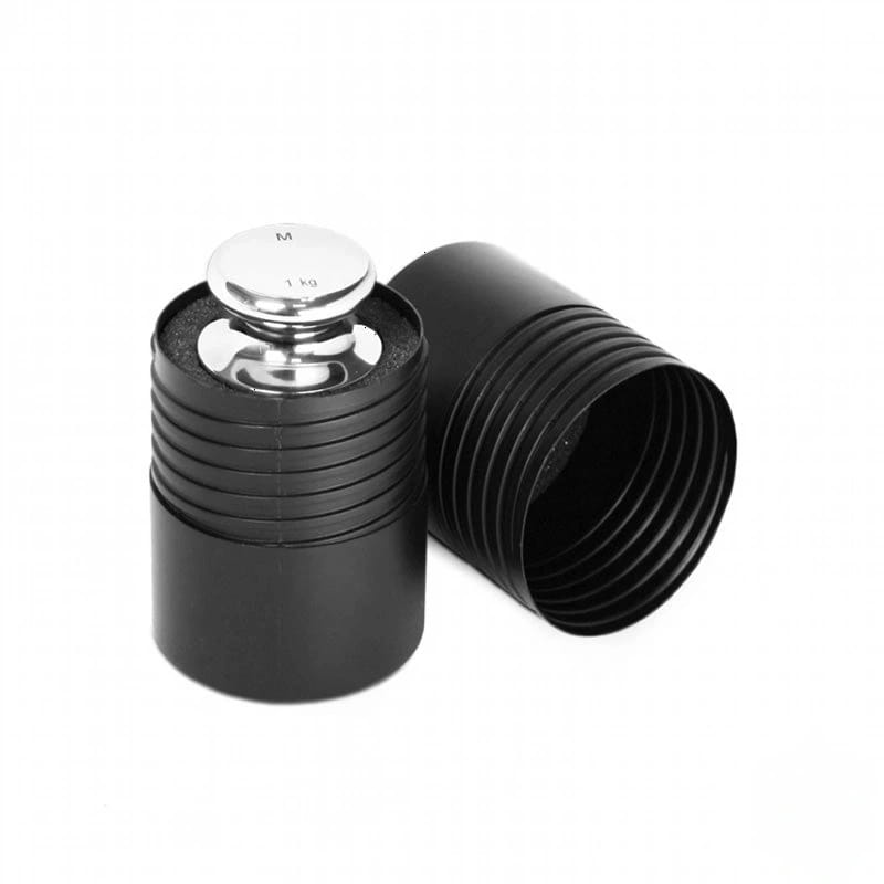 A sleek, 1 kg silver calibration weight nestled inside a black ribbed cylindrical container