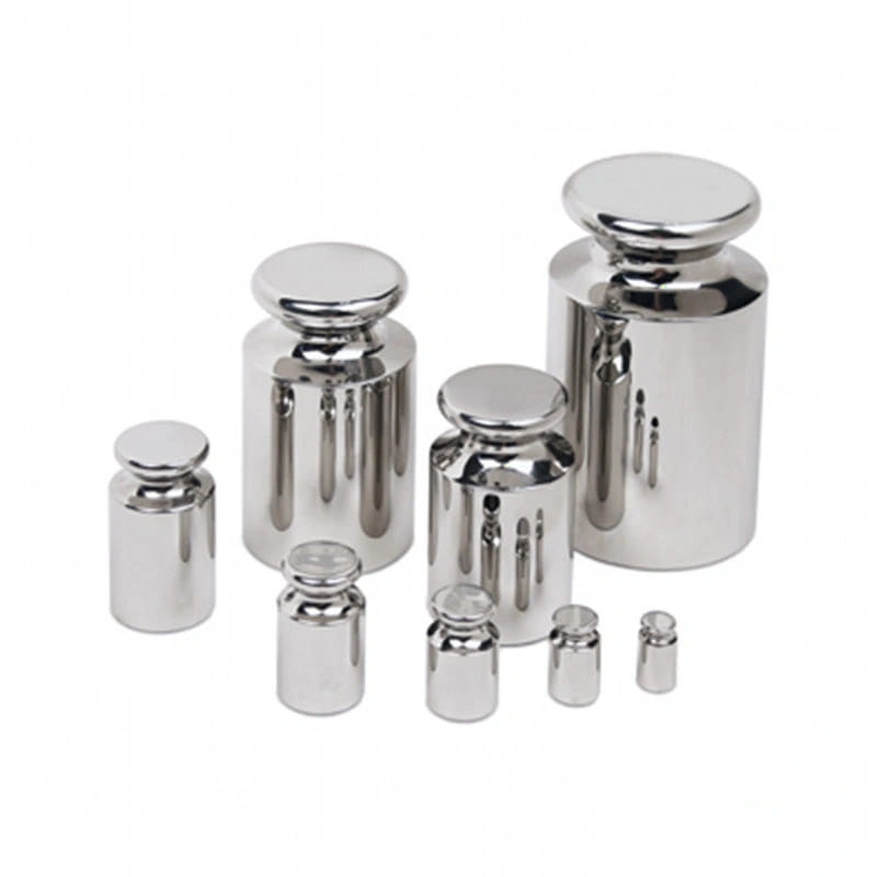 Set of stainless steel calibration weights with polished, reflective surfaces and rounded tops
