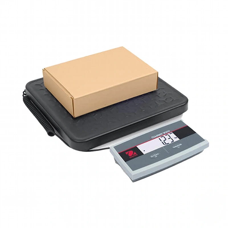 Black digital scale with gray display showing 123.4 pounds, featuring a coiled power cord and textured platform holding a brown cardboard box