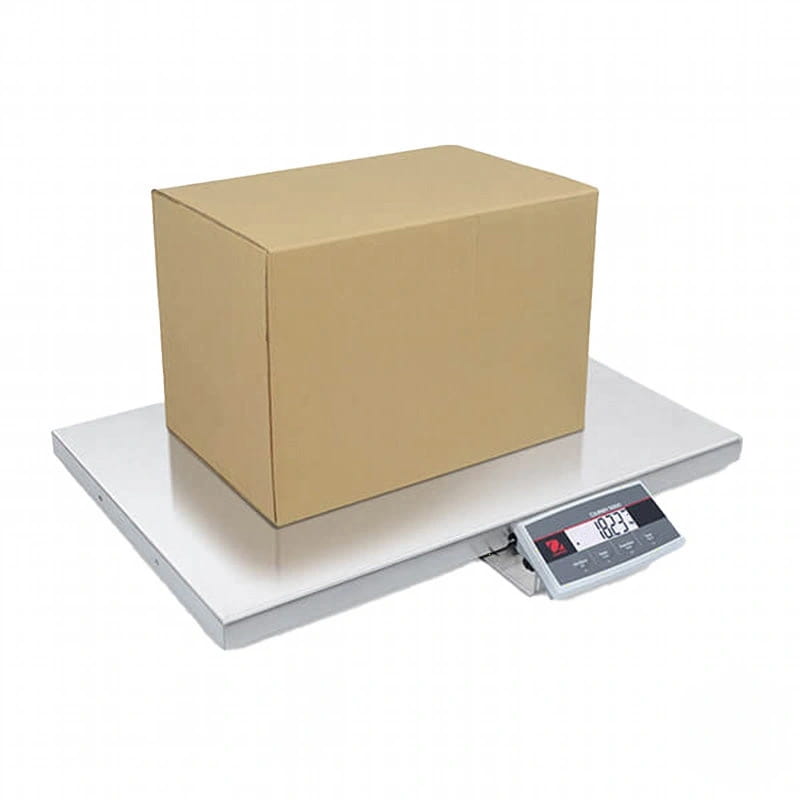 Silver digital platform scale with a brown cardboard box resting on its weighing surface