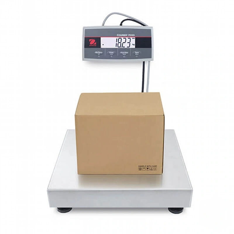 Silver digital platform scale with a brown cardboard box resting on its surface