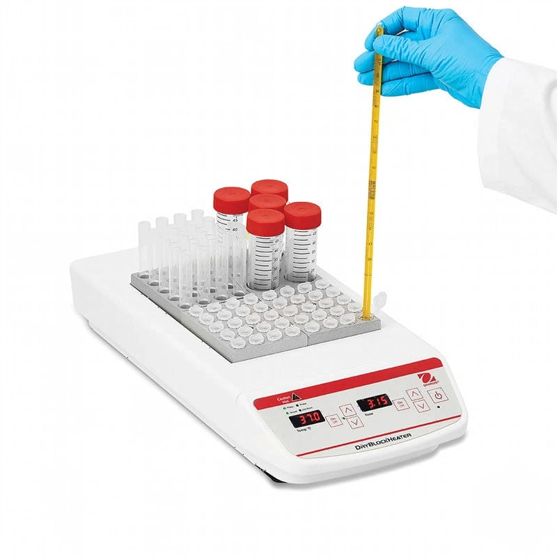 White and red digital dry bath heater with a gray tray holding clear test tubes with red caps