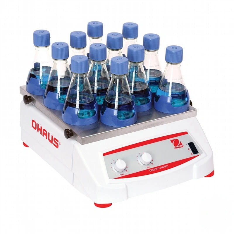 White ohaus orbital shaker with red accents and silver platform holding multiple blue-capped glass flasks filled with liquid