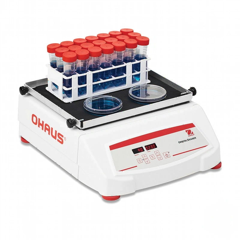 White ohaus orbital shaker with red accents and digital display, featuring a tray holding test tubes and two petri dishes on its platform