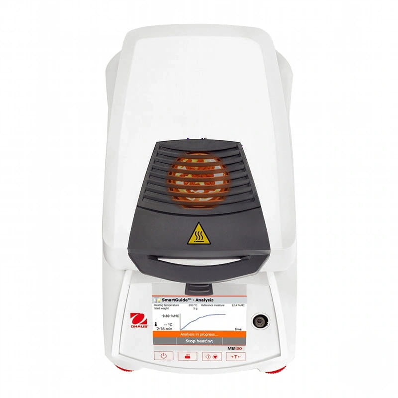 White ohrus mb 120 laboratory instrument with a black heating chamber and digital display showing analysis progress