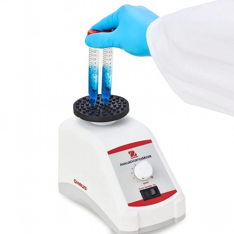 White and red ohaus analog vortex mixer with black rotor holding two blue liquid-filled test tubes