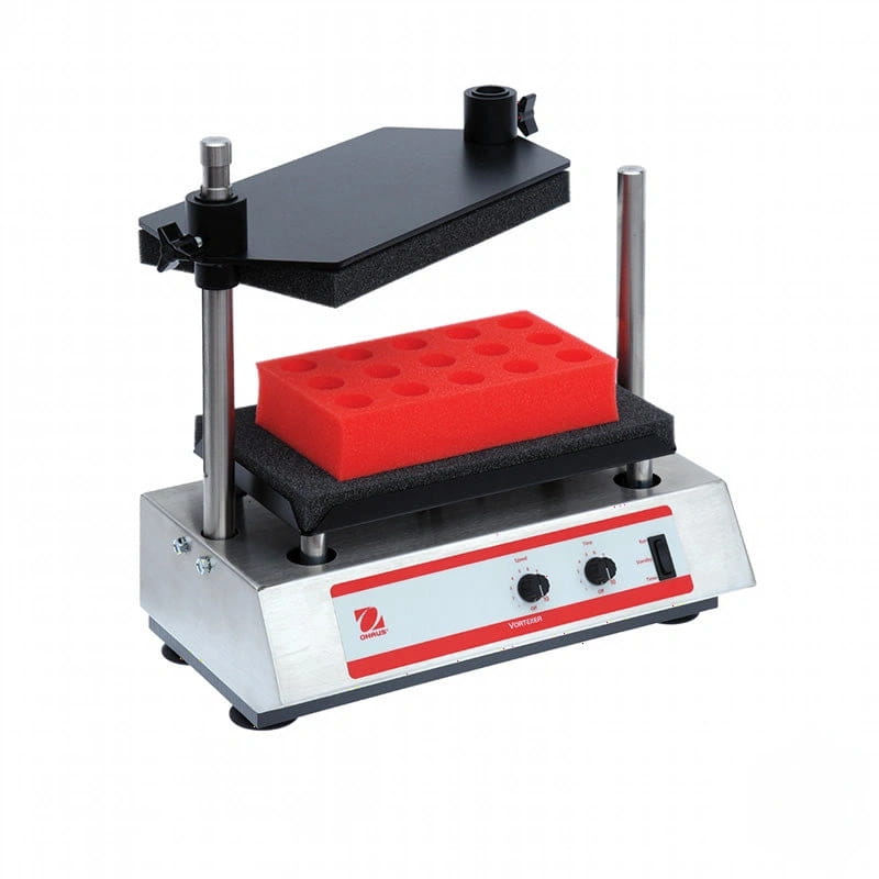 Red rectangular foam block with circular indentations sits on a black platform within a silver and red laboratory shaker