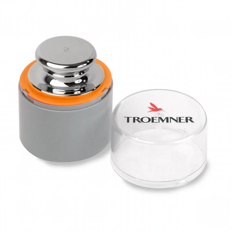 Silver chrome-plated 2 kg calibration weight with an orange rubber ring, housed in a gray plastic case and accompanied by its clear protective lid