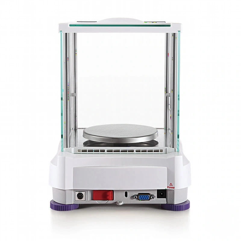 White laboratory precision balance with a transparent glass enclosure, silver weighing platform, and purple rubber feet