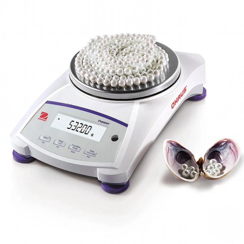 White and purple ohaus pioneer analytical balance with a digital display showing 53.200 grams, holding a pile of small white pearls on its weighing platform