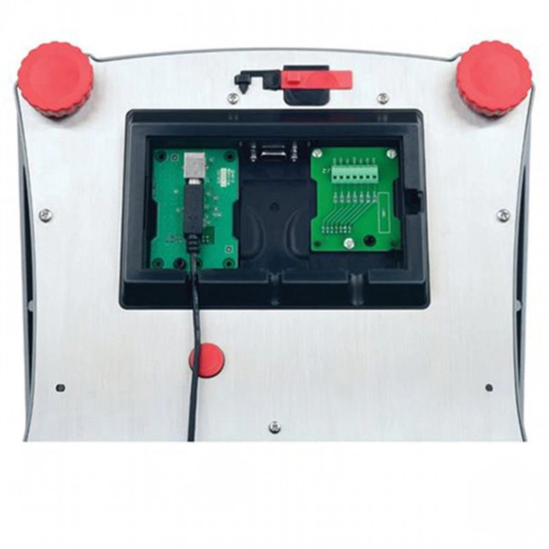 Silver metallic arcade joystick with red knobs and a black cable plugged into its internal green circuit boards