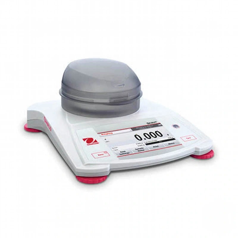 White digital laboratory scale with a transparent dome lid and red foot pads, featuring the ohaus brand logo