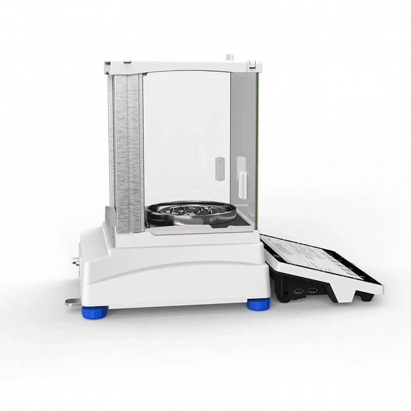 White analytical balance with a transparent draft shield, metallic weighing pan, and blue feet
