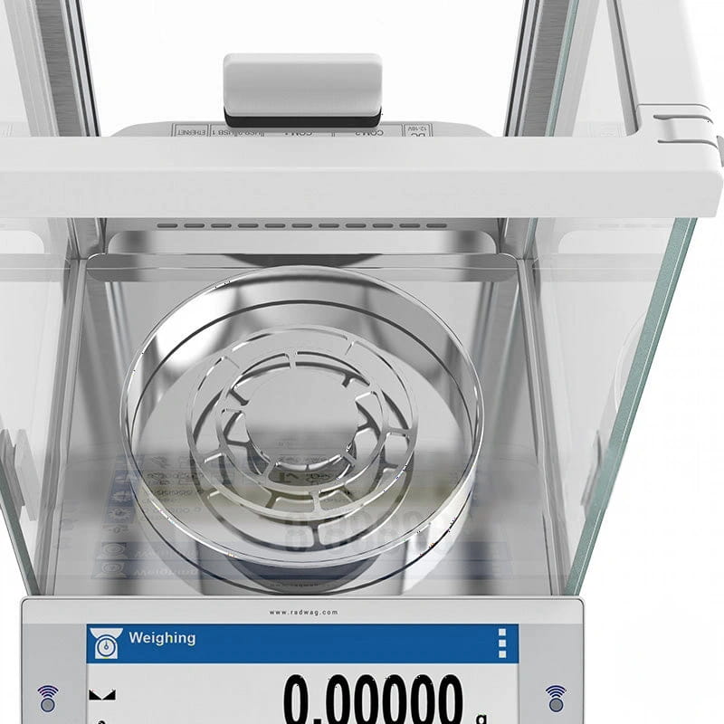 White analytical balance with a clear glass enclosure and stainless steel weighing pan