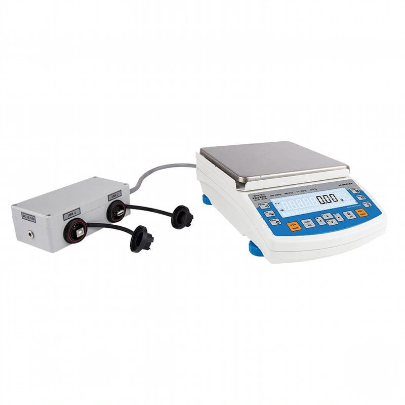 White digital scale with a silver weighing platform and blue control panel, connected to a white calibration unit via black cables