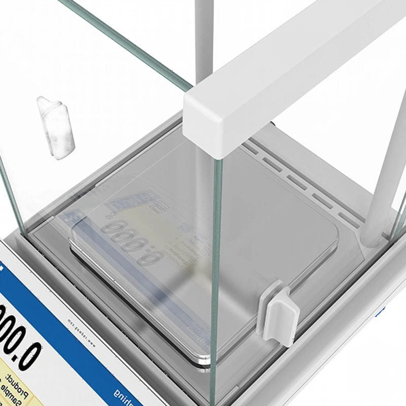 White laboratory balance with transparent glass enclosure and digital display